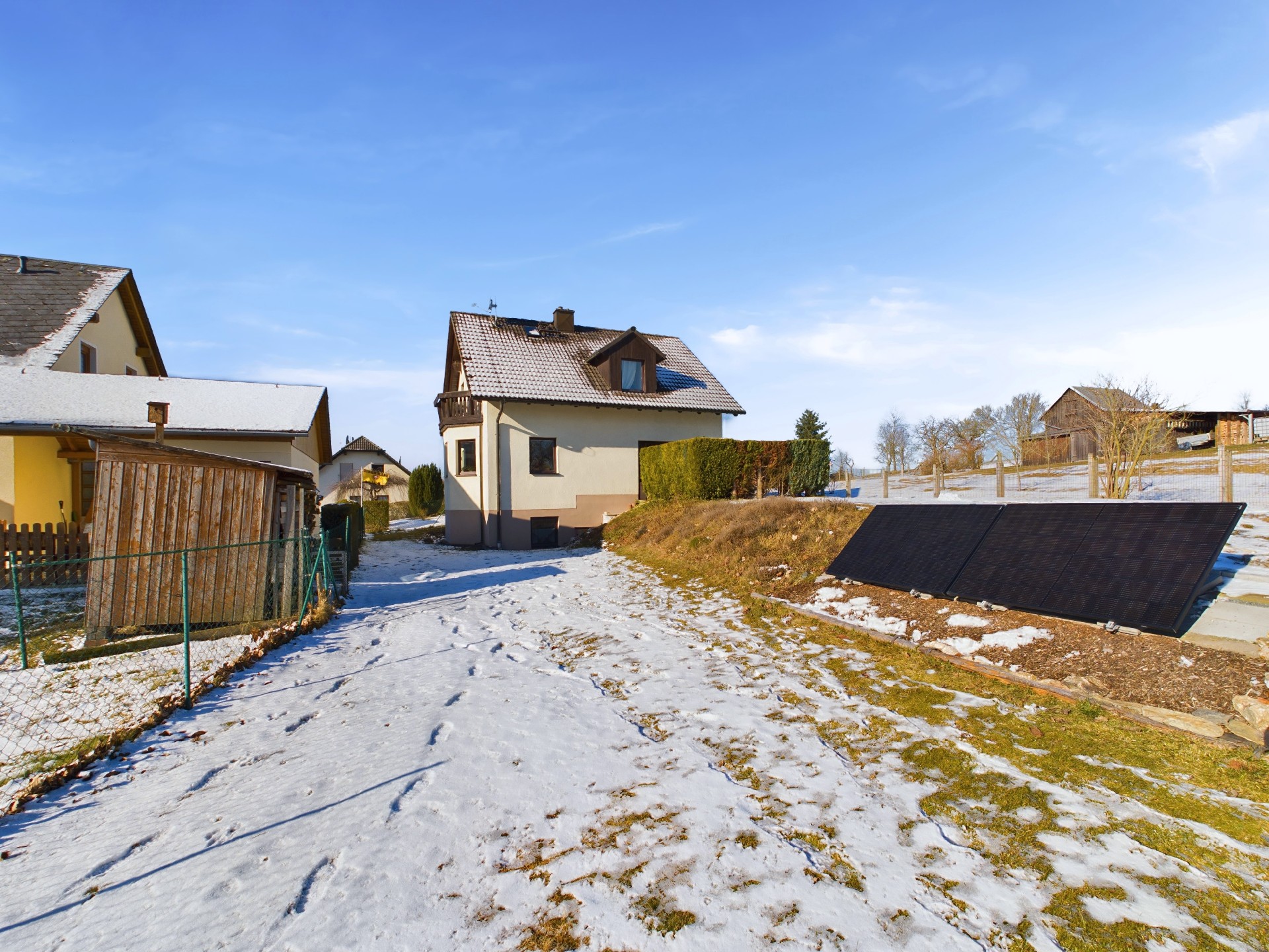 Hausansicht rückseitig mit 2 Photovoltaikplatten ("Balkonkraftwerk")