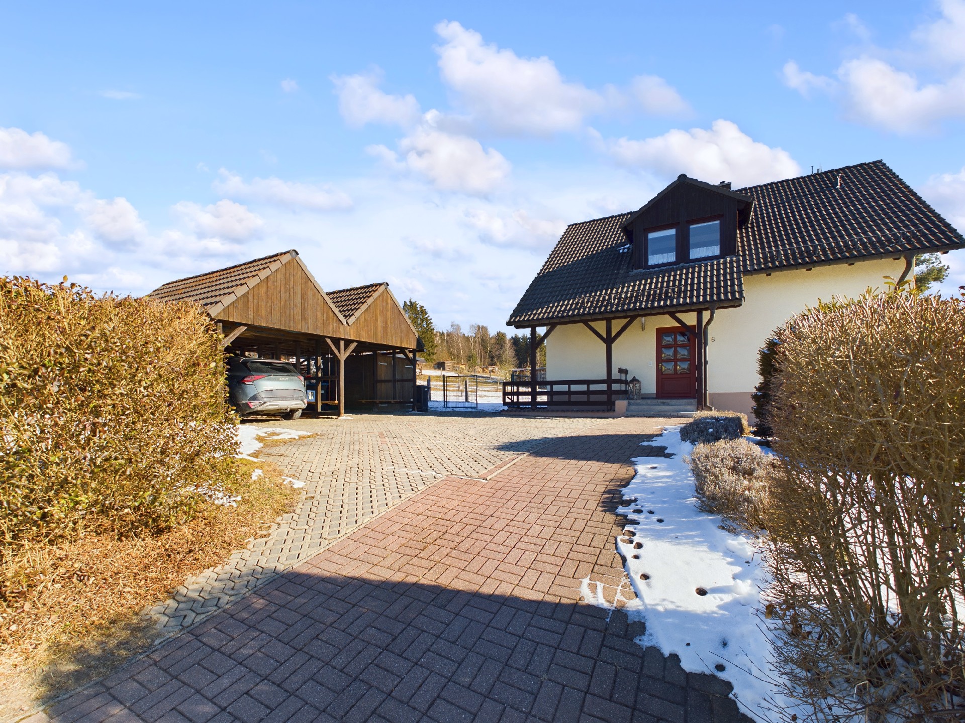 Hausansicht mit Einfahrt und Doppel-Carport