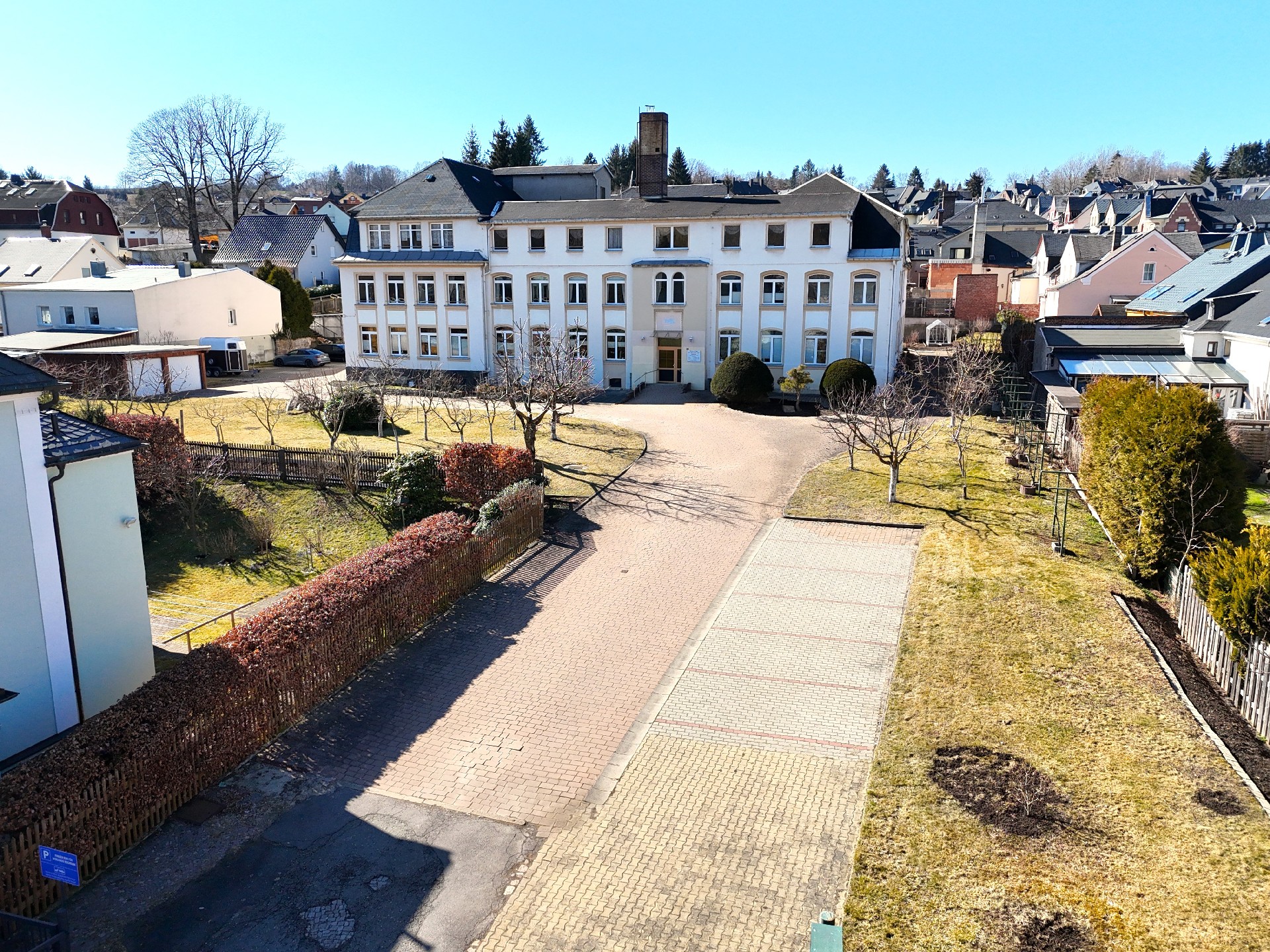 Außenansicht mit Zufahrt und Parkplätzen