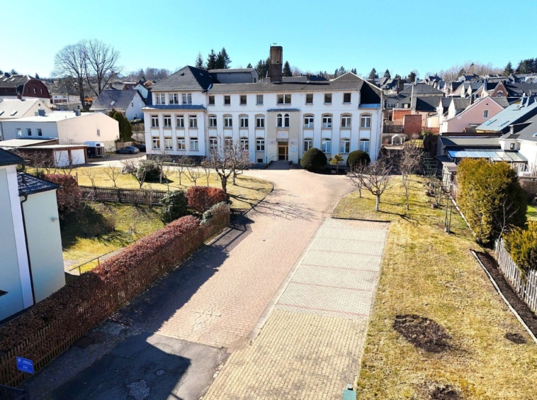 Außenansicht mit Zufahrt und Parkplätzen